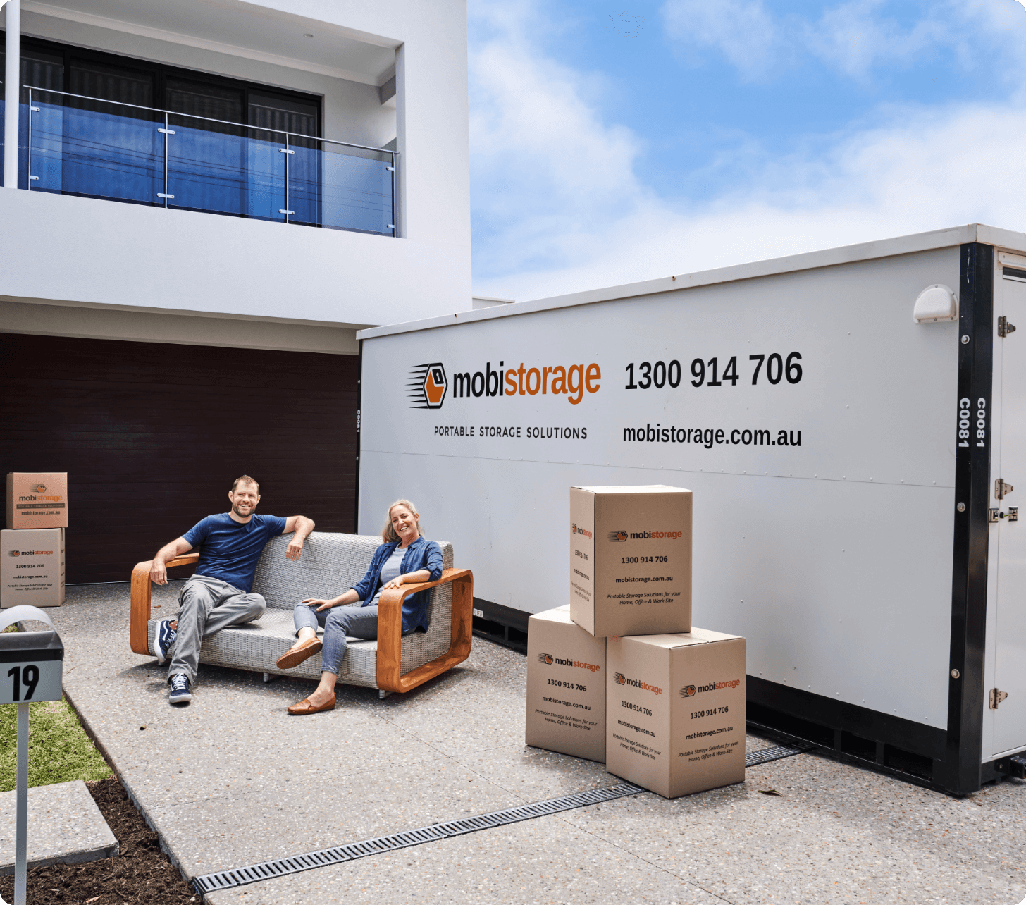 A couple sitting on their coach with their brown boxes